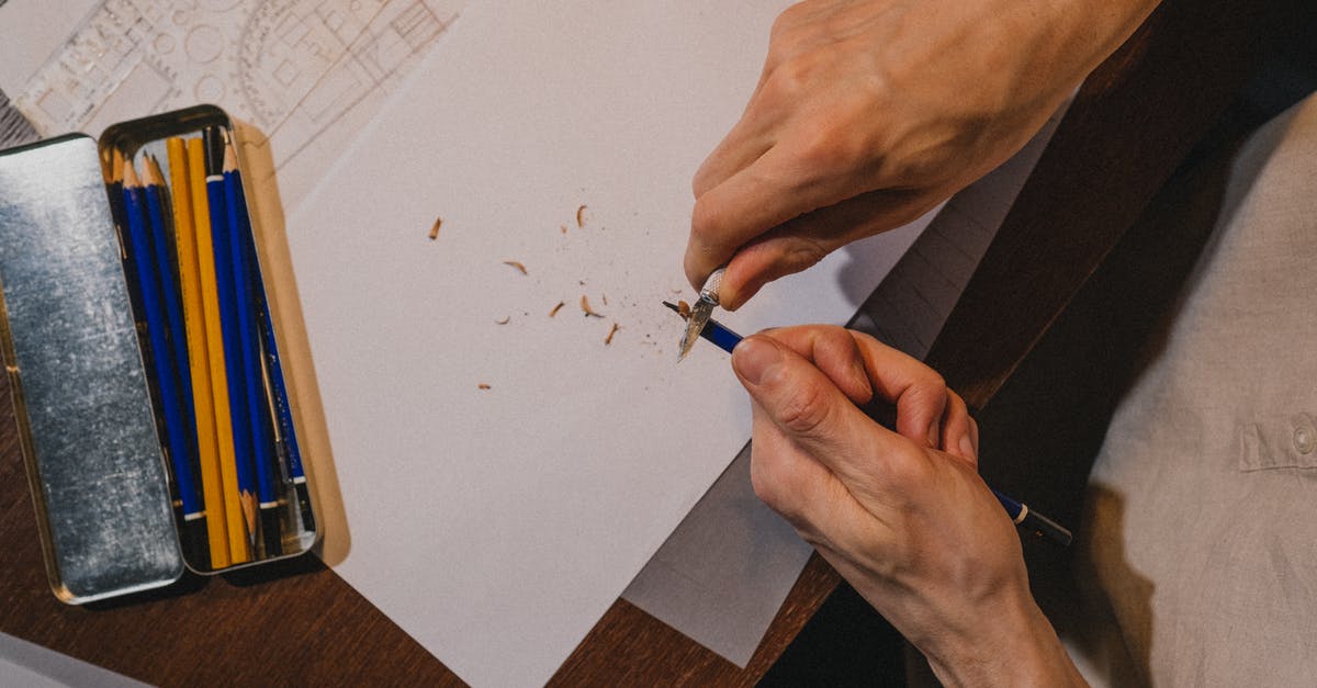 Tempering chocolate: ± 2 °C too much? - Close up on mans hands tempering pencil over drawing Tempering chocolate: ± 2 °C too much? - Close up on mans hands tempering pencil over drawing