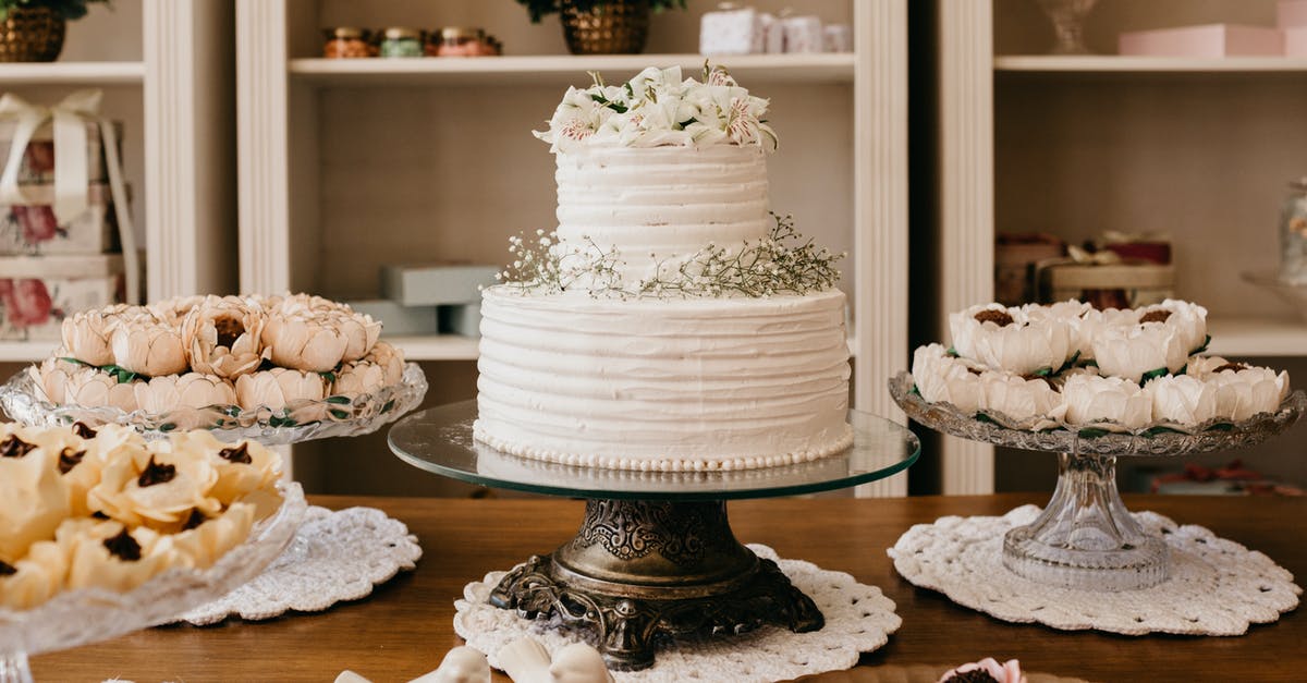 Test if whitish chocolate has bloom or is spoiled - Wedding cake with floral decor between treats on table Test if whitish chocolate has bloom or is spoiled - Wedding cake with floral decor between treats on table