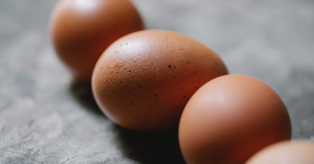 Thawing uncooked chicken [duplicate] - High angle of row of uncooked fresh brown chicken eggs placed on gray table in kitchen