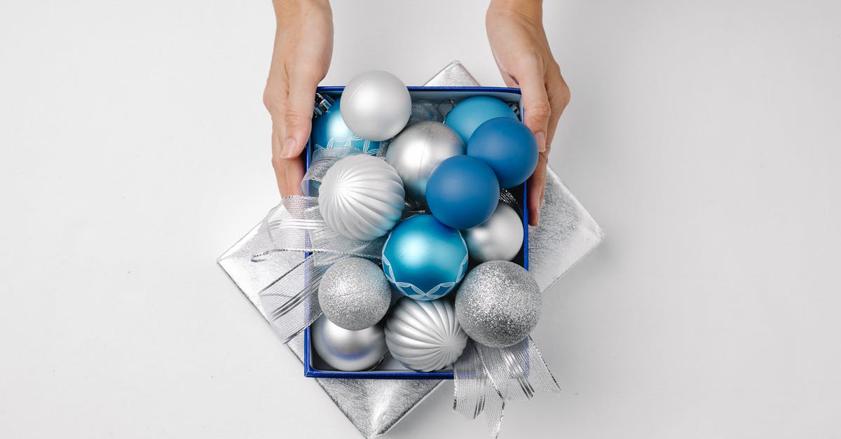 The inside of my grill lid is rusting - Top view of anonymous person with silver and blue Christmas balls on lid present of box placed on white background The inside of my grill lid is rusting - Top view of anonymous person with silver and blue Christmas balls on lid present of box placed on white background