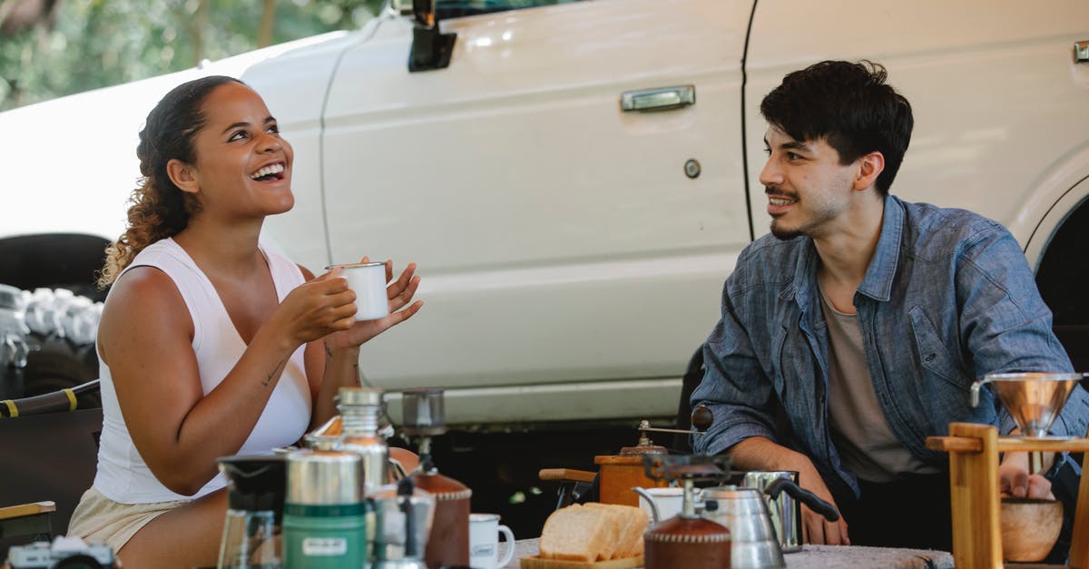 the whistle on the kettle keeps popping off - Positive multiethnic couple having lunch during picnic in nature the whistle on the kettle keeps popping off - Positive multiethnic couple having lunch during picnic in nature