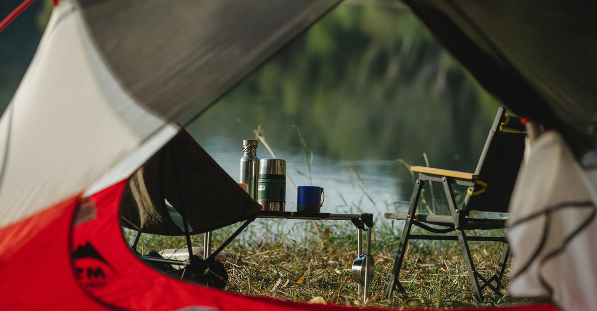 Thermo bottle for impromptu sous vide? - Through tent hole view of portable chairs and table with thermoses on grass shore against lake Thermo bottle for impromptu sous vide? - Through tent hole view of portable chairs and table with thermoses on grass shore against lake