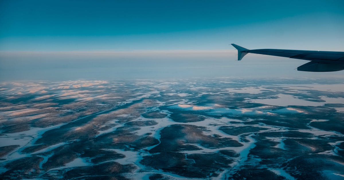 Thermometers for high temperature ovens - Wing of airplane flying in blue cloudless sky with skyline above vast terrain covered with snow in nature on winter day Thermometers for high temperature ovens - Wing of airplane flying in blue cloudless sky with skyline above vast terrain covered with snow in nature on winter day
