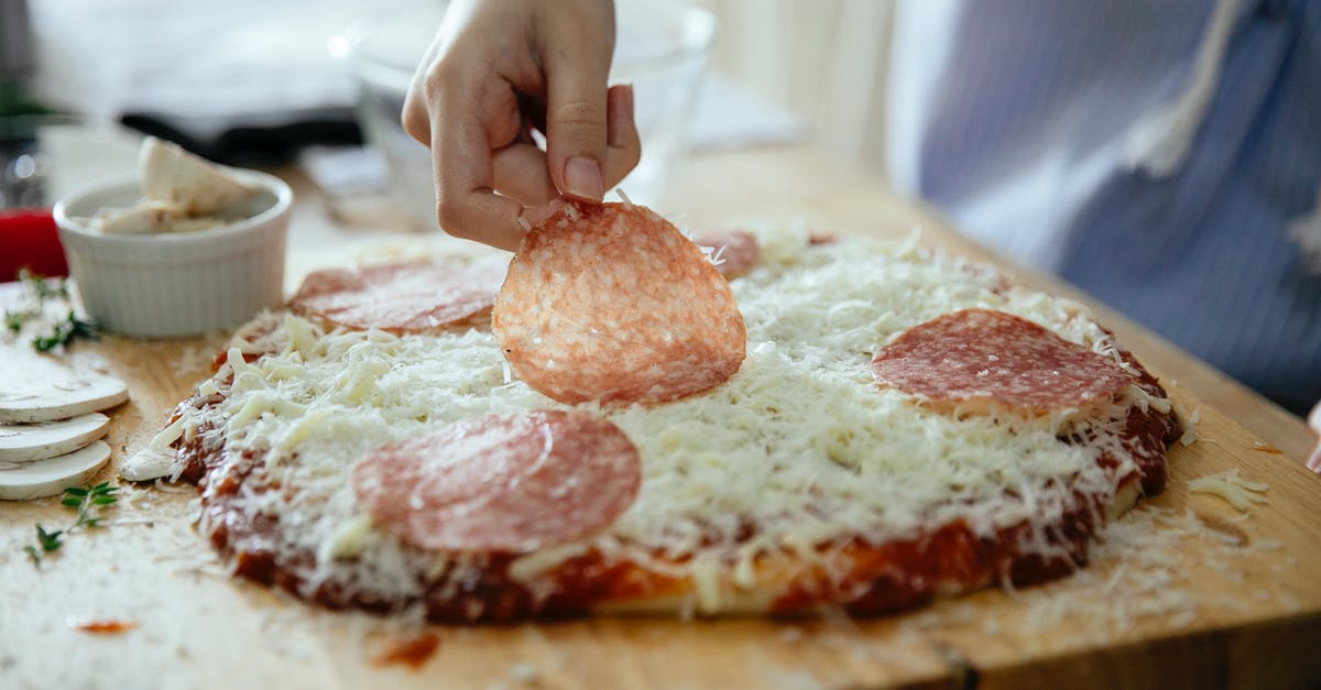 Thicker gelatin layer at the bottom of the dish - Crop anonymous person putting slice of salami on yummy homemade on wooden cutting board while cooking in kitchen Thicker gelatin layer at the bottom of the dish - Crop anonymous person putting slice of salami on yummy homemade on wooden cutting board while cooking in kitchen