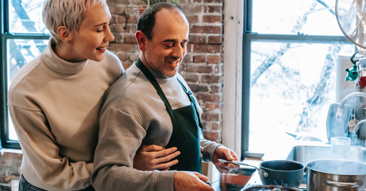 Time of cooking: induction stove vs gas stove - Content man with girlfriend frying meatballs in pan at home Time of cooking: induction stove vs gas stove - Content man with girlfriend frying meatballs in pan at home