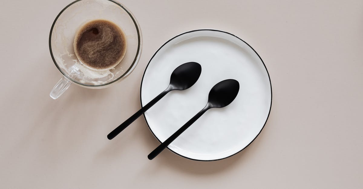 Tips/resources for learning how to plate dishes - From above composition of ceramic plate with black spoons placed near glass cup of coffee on beige table Tips/resources for learning how to plate dishes - From above composition of ceramic plate with black spoons placed near glass cup of coffee on beige table