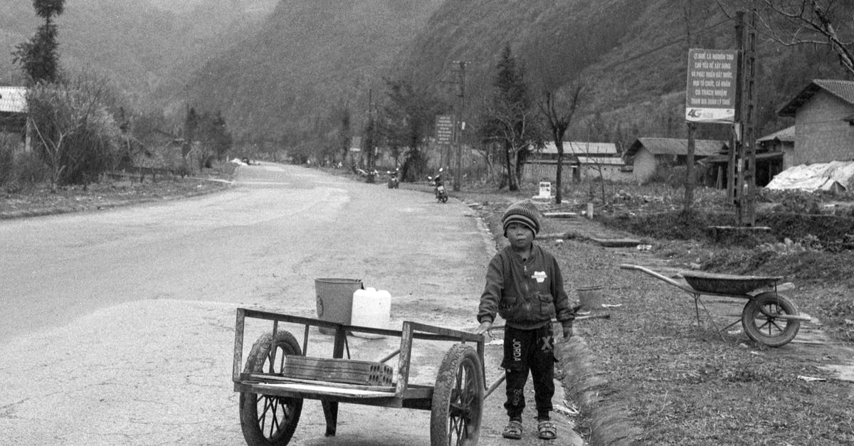 To lid or not to lid? - Grayscale Photo of Man in Jacket Sitting on Bench Near Mountain To lid or not to lid? - Grayscale Photo of Man in Jacket Sitting on Bench Near Mountain