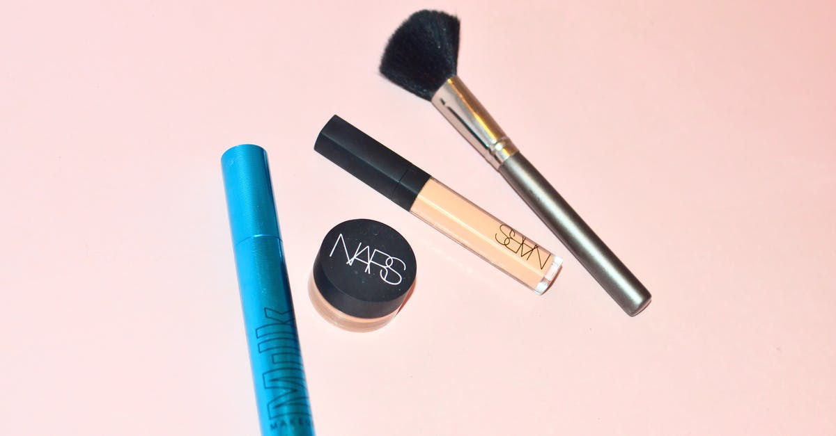 Toning down lamb with mustard powder: universal tool? - Top view of professional mascara concealer and cosmetic foundation placed near brush for applying makeup on pink background in studio Toning down lamb with mustard powder: universal tool? - Top view of professional mascara concealer and cosmetic foundation placed near brush for applying makeup on pink background in studio