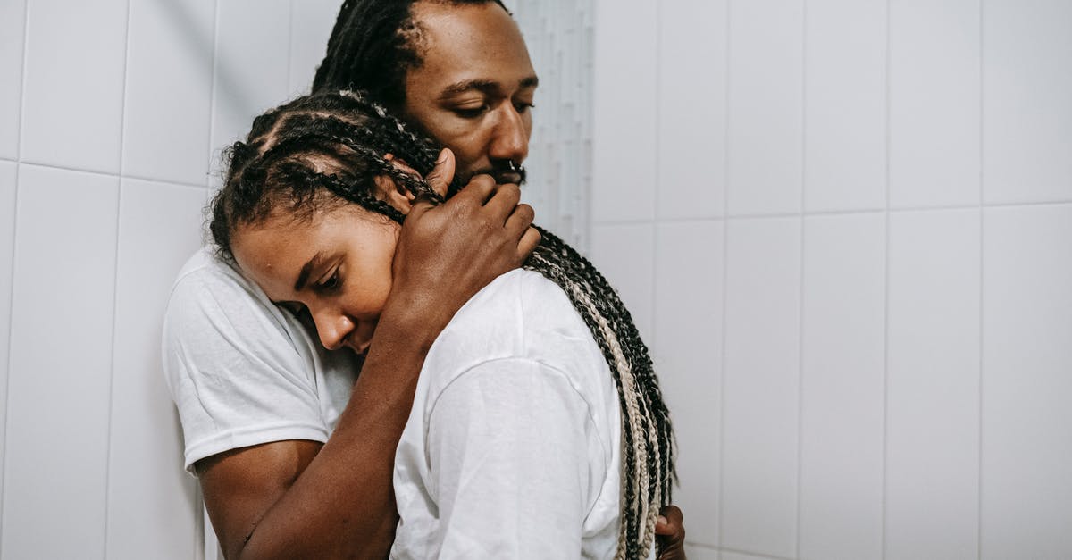 Trouble making a crunchy dog treat [closed] - Stressed sad African American couple in white shirts embracing each other in light bathroom