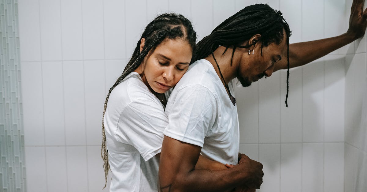 Trouble making a crunchy dog treat [closed] - Side view sad loving African American female in white shirt standing behind and embracing depressed unhappy husband in bathroom