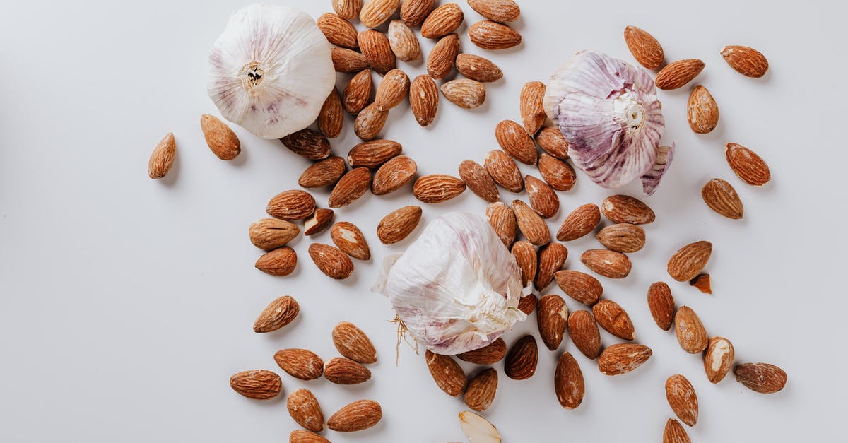 TVP - textured vegetable protein - Raw almonds and heads of garlic on white background TVP - textured vegetable protein - Raw almonds and heads of garlic on white background