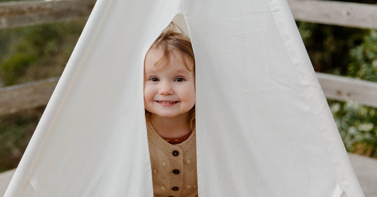 UHT Milk: small white floating stuff? - Happy little child smiling while peeking from tent UHT Milk: small white floating stuff? - Happy little child smiling while peeking from tent