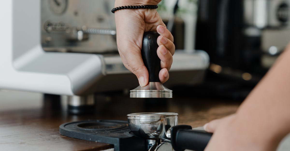 Using a French press with finely ground coffee - Unrecognizable female bartender pressuring ground coffee in portafilter with tamper for preparing tasty aromatic espresso during work in coffee house Using a French press with finely ground coffee - Unrecognizable female bartender pressuring ground coffee in portafilter with tamper for preparing tasty aromatic espresso during work in coffee house