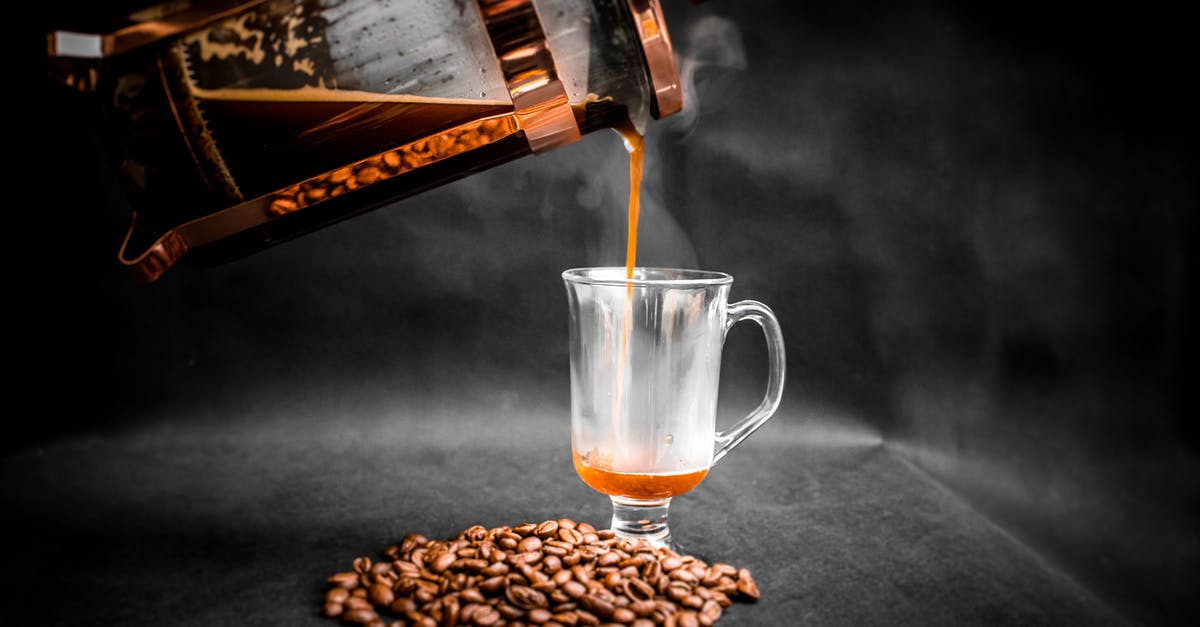 Using a French press with finely ground coffee - Aromatic hot coffee being poured from French press into elegant glass with pile of coffee beans beside on black background Using a French press with finely ground coffee - Aromatic hot coffee being poured from French press into elegant glass with pile of coffee beans beside on black background