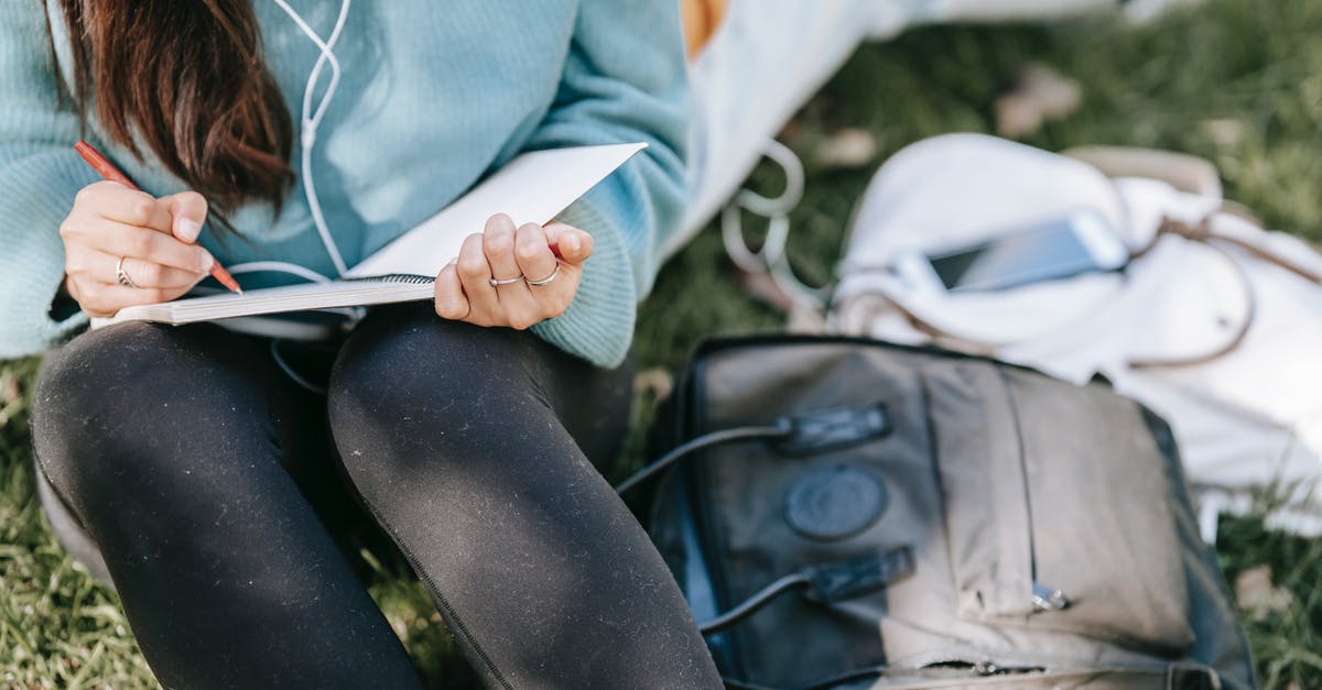 Using a Jelly Bag - Crop anonymous female listening to music in earphones while writing in notebook near bags on grass Using a Jelly Bag - Crop anonymous female listening to music in earphones while writing in notebook near bags on grass