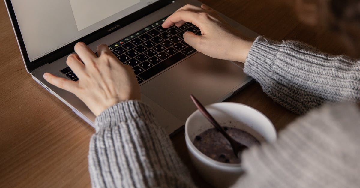 Using a wooden spoon to prevent pots from boiling over? - From above unrecognizable woman in gray sweater sitting at wooden table with food in bowl and creating document while working on remote project at home Using a wooden spoon to prevent pots from boiling over? - From above unrecognizable woman in gray sweater sitting at wooden table with food in bowl and creating document while working on remote project at home
