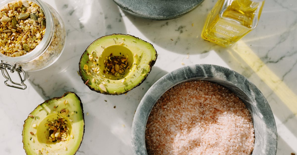 Using avocado oil as a substitute to olive oil - Fresh avocado halves with seed mix and other ingredients for healthy breakfast Using avocado oil as a substitute to olive oil - Fresh avocado halves with seed mix and other ingredients for healthy breakfast