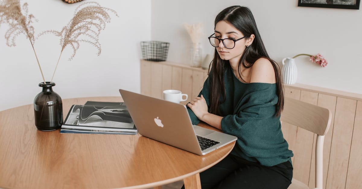 Using decorative loaf pans - Thoughtful female freelancer watching laptop in light room at home Using decorative loaf pans - Thoughtful female freelancer watching laptop in light room at home