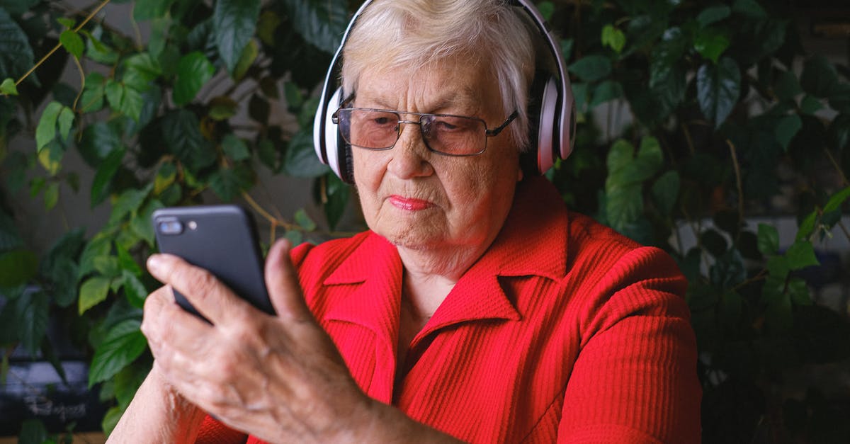 Using the right acid for red curry - Focused aged woman browsing smartphone while listening to song Using the right acid for red curry - Focused aged woman browsing smartphone while listening to song