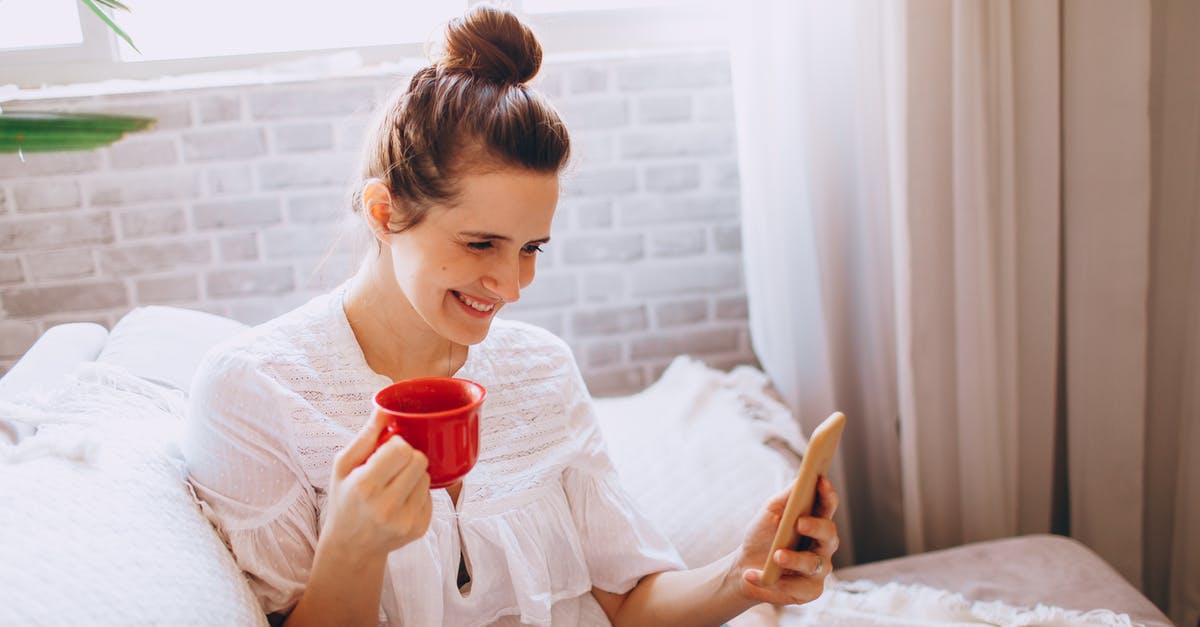 Using the right acid for red curry - Young cheerful female in casual clothes sitting on sofa and drinking coffee while using smartphone Using the right acid for red curry - Young cheerful female in casual clothes sitting on sofa and drinking coffee while using smartphone
