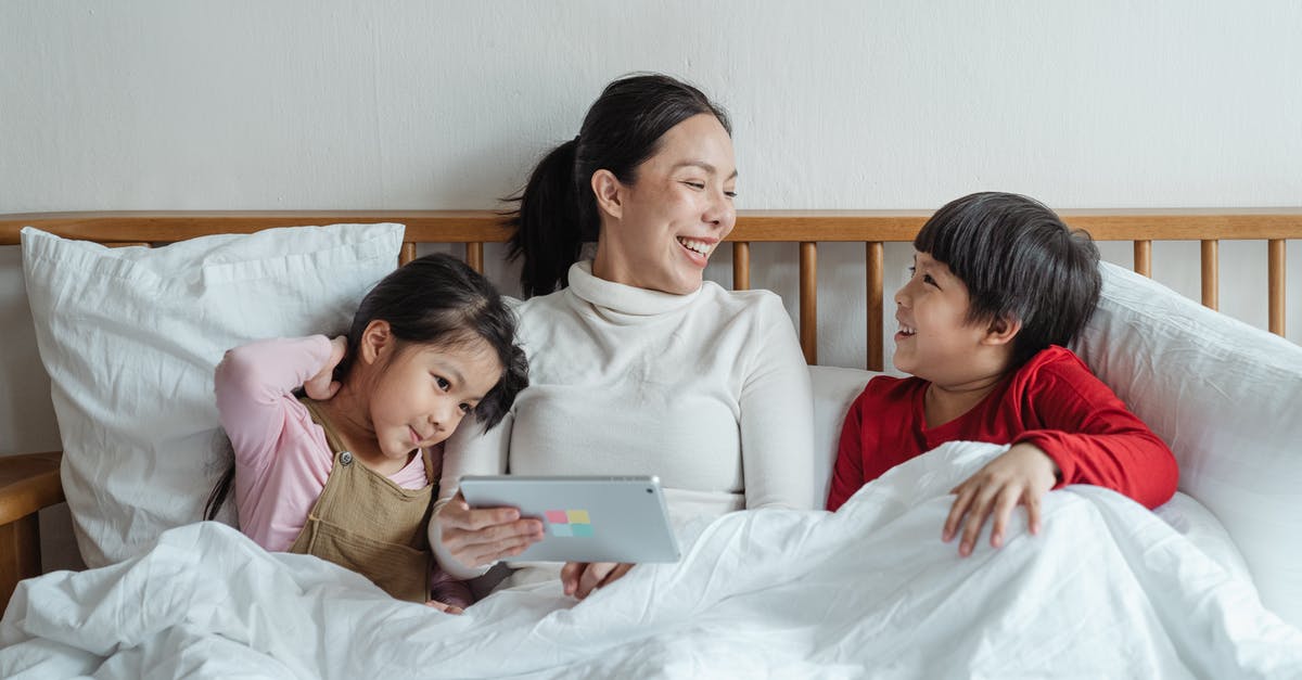 Using yeast that's been proofed - Positive ethnic mother and little daughter and son having fun together in cozy bed in morning while using tablet Using yeast that's been proofed - Positive ethnic mother and little daughter and son having fun together in cozy bed in morning while using tablet