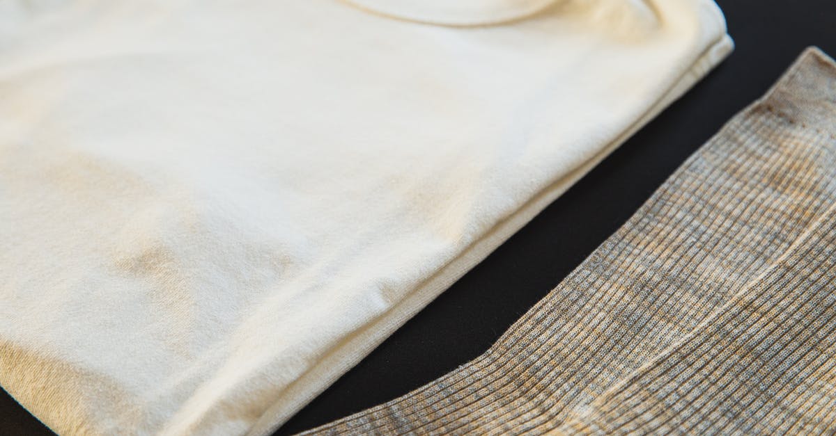Vanilla fudge won't set - High angle of white folded cotton t shirt with round shaped neckline near striped socks for man on black background Vanilla fudge won't set - High angle of white folded cotton t shirt with round shaped neckline near striped socks for man on black background