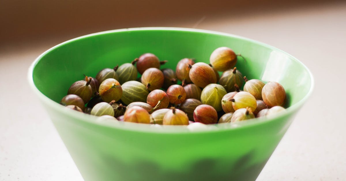 Vegetarian Alternative to Bacon-wrapped Sausages? - High angle of ripe gooseberries in green deep plastic bowl on table on summer day Vegetarian Alternative to Bacon-wrapped Sausages? - High angle of ripe gooseberries in green deep plastic bowl on table on summer day
