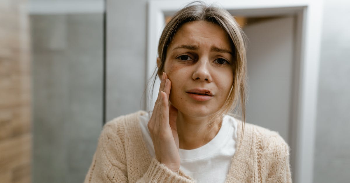Vinegar and battered chicken? - A Woman in Beige Sweater Touching her Bruised Face Vinegar and battered chicken? - A Woman in Beige Sweater Touching her Bruised Face