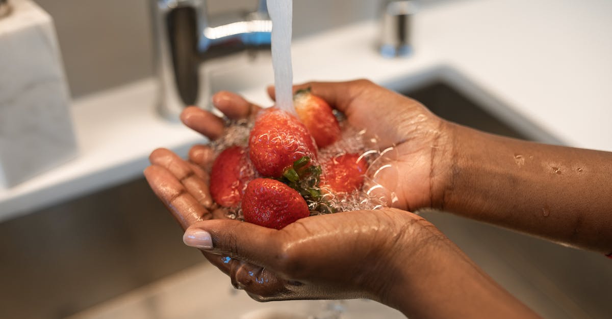 Washing Griddle before first use - Person Washing Red Strawberries Washing Griddle before first use - Person Washing Red Strawberries