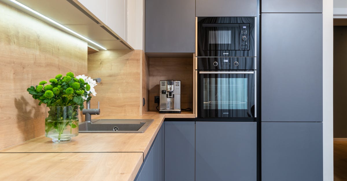 Water in the microwave to reheat pizza better - Creative design of kitchen with built in oven against coffee machine and flowers in vase on table in house Water in the microwave to reheat pizza better - Creative design of kitchen with built in oven against coffee machine and flowers in vase on table in house
