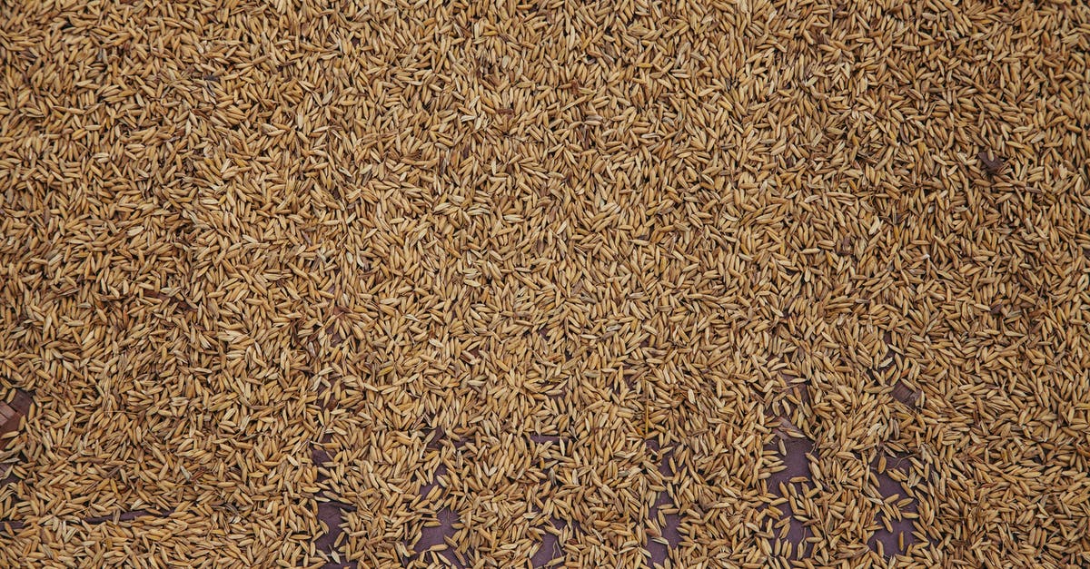 What's the best way to cook brown rice? - From above of pile of raw brown rice scattered on table as background What's the best way to cook brown rice? - From above of pile of raw brown rice scattered on table as background
