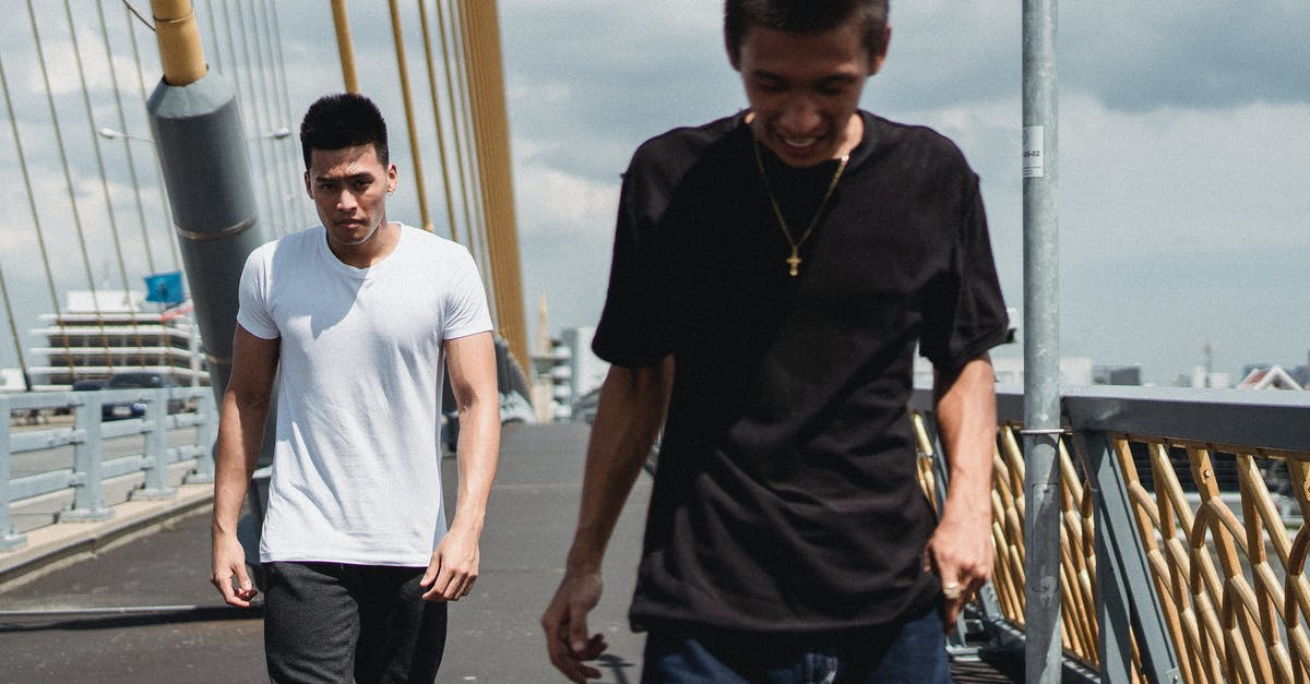 What's the best way to grate chocolate? - Young Asian men walking on asphalt bridge What's the best way to grate chocolate? - Young Asian men walking on asphalt bridge