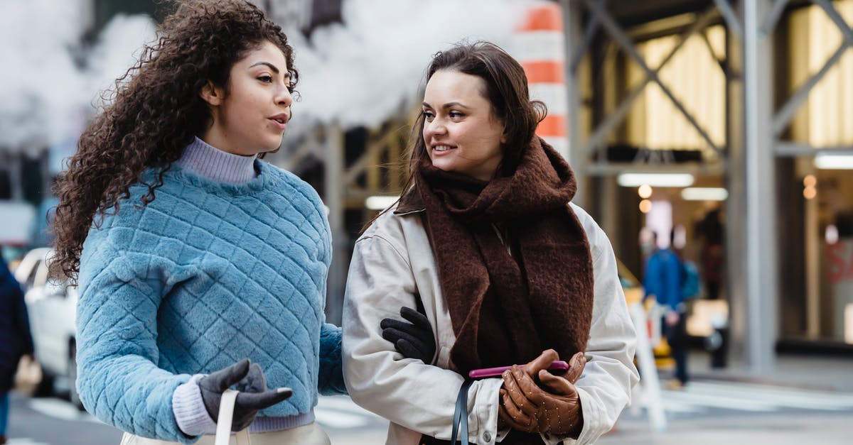 What's the best way to make Béchamel sauce? - Positive stylish multiethnic women talking and crossing road in city What's the best way to make Béchamel sauce? - Positive stylish multiethnic women talking and crossing road in city