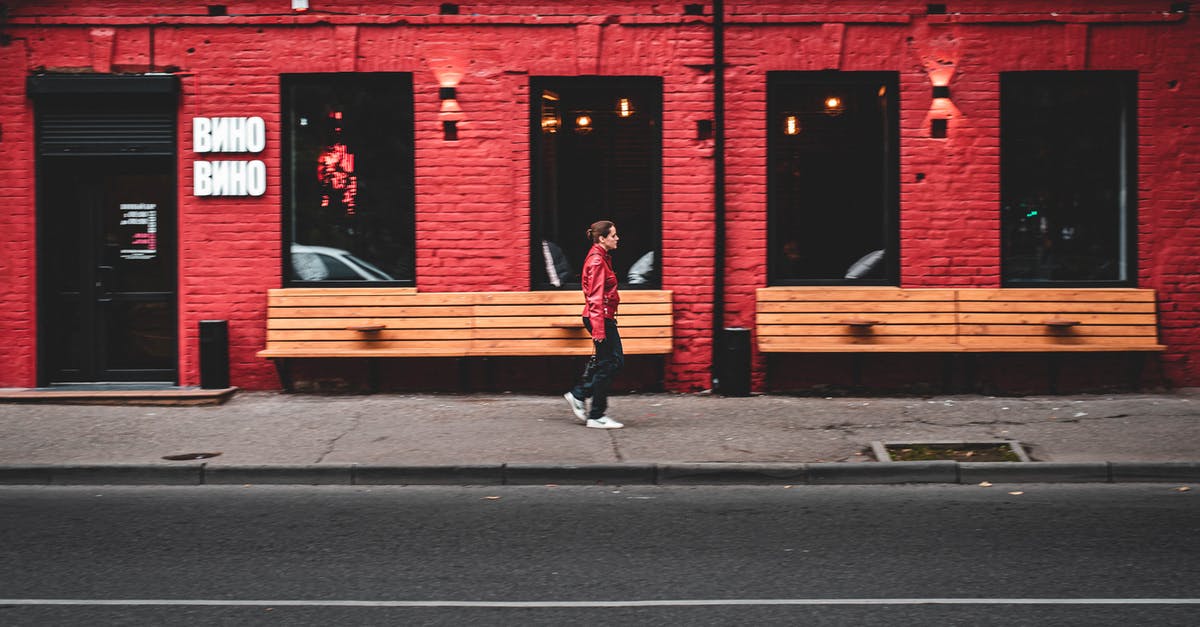 What's the best way to store unused sushi rice? - Side view of modern female walking on sidewalk near red building on city street