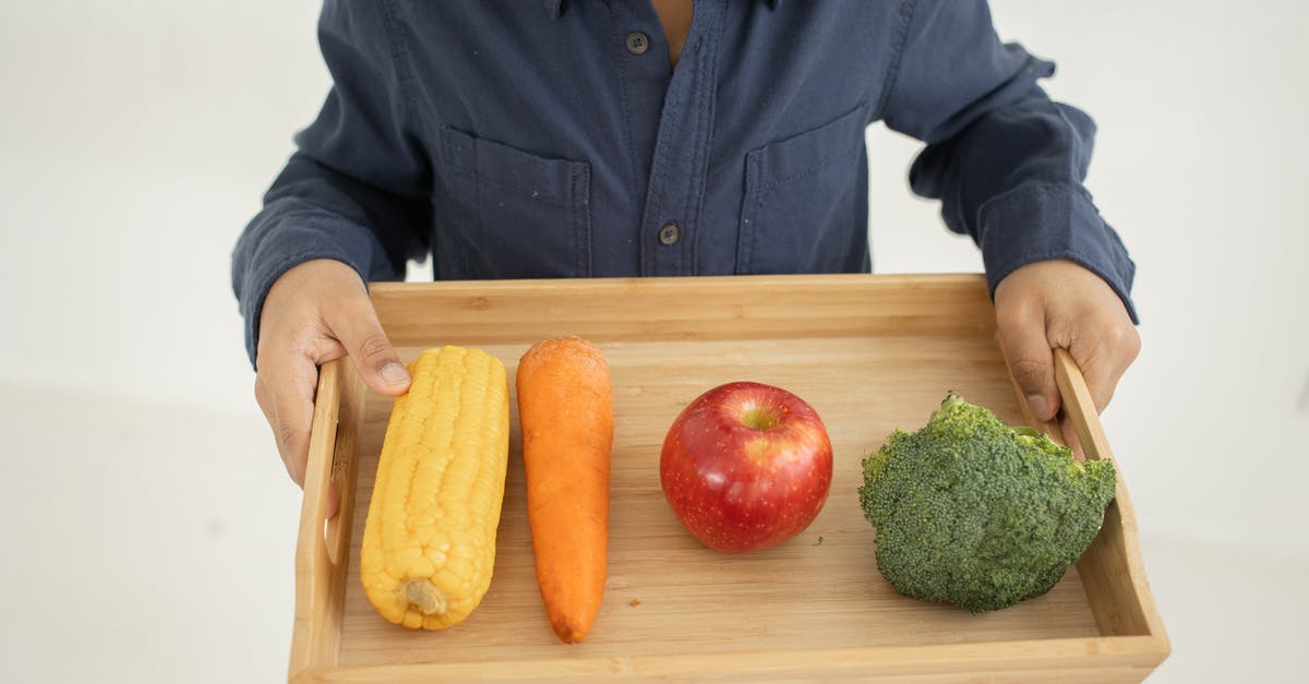 What's the difference between broccoli from China and broccoli from Australia? - From above of crop anonymous kid in casual outfit holding wooden tray with fresh healthy broccoli apple carrot and corn against white background What's the difference between broccoli from China and broccoli from Australia? - From above of crop anonymous kid in casual outfit holding wooden tray with fresh healthy broccoli apple carrot and corn against white background