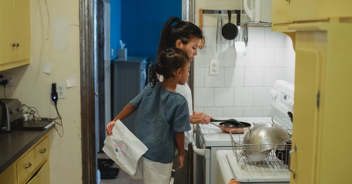 What's the functional different between a skillet and a saute pan? - Mother and daughter cooking in kitchen