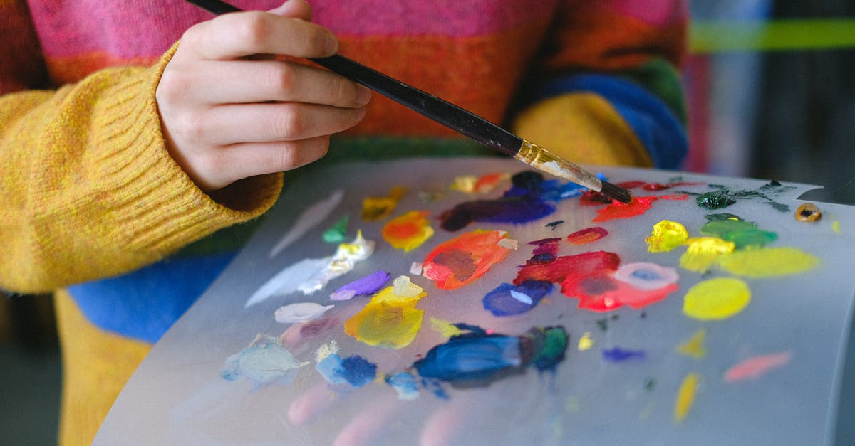 What's the least messy way to prepare grapefruit? - Crop anonymous female artist in casual clothes standing in light studio with paintbrush while mixing various paints on paper