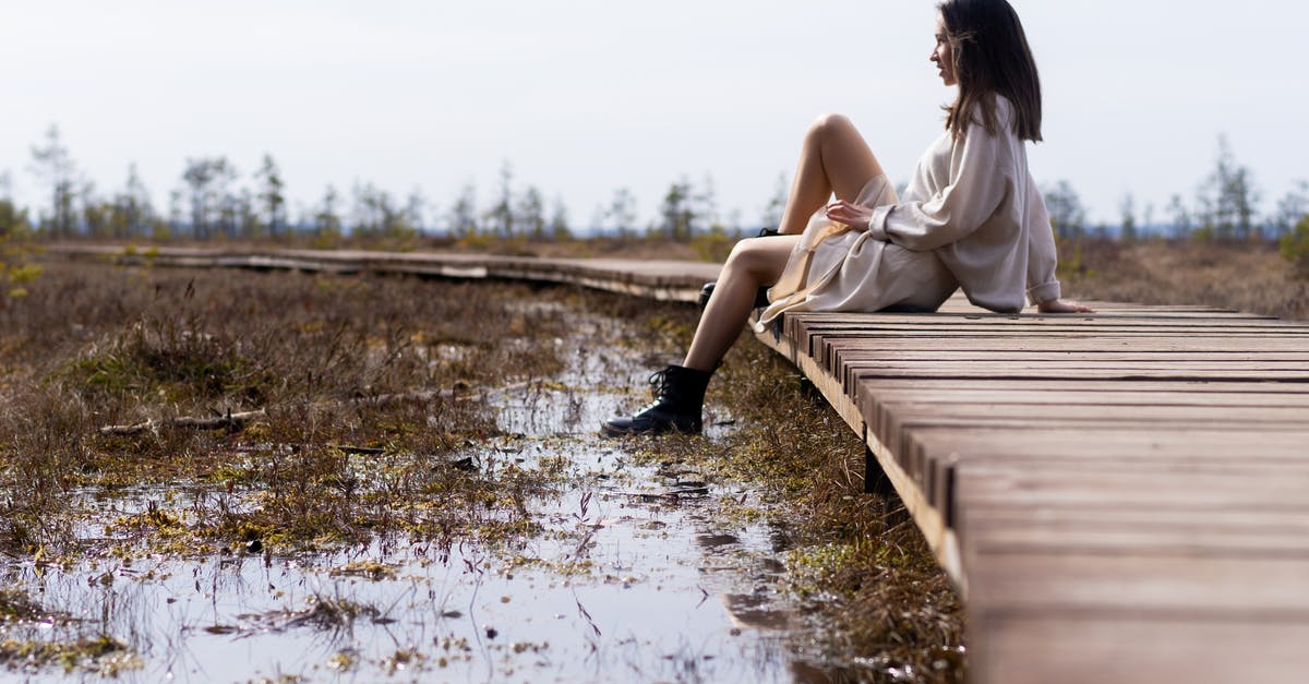 What's this salad of gray lumps in white dressing? - Woman in white dress resting on wooden path near water What's this salad of gray lumps in white dressing? - Woman in white dress resting on wooden path near water