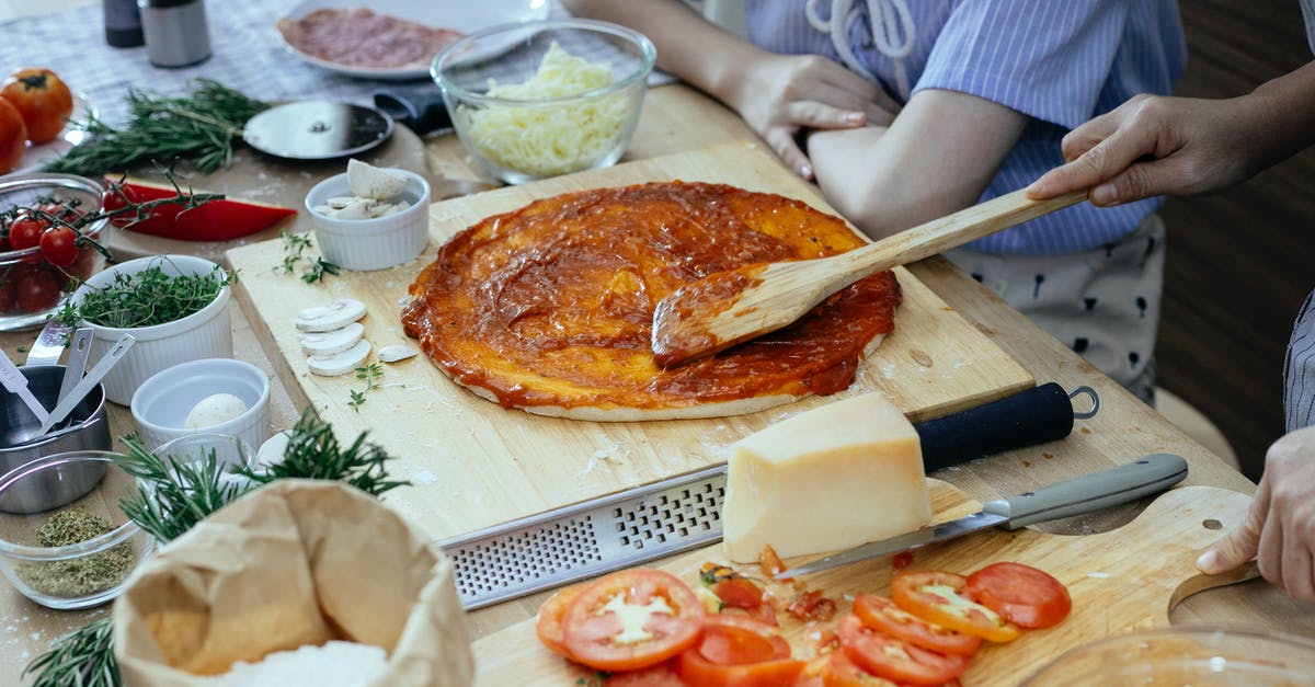 What alternatives are there to tomato based pizza sauces? - Women in process of preparing homemade pizza What alternatives are there to tomato based pizza sauces? - Women in process of preparing homemade pizza