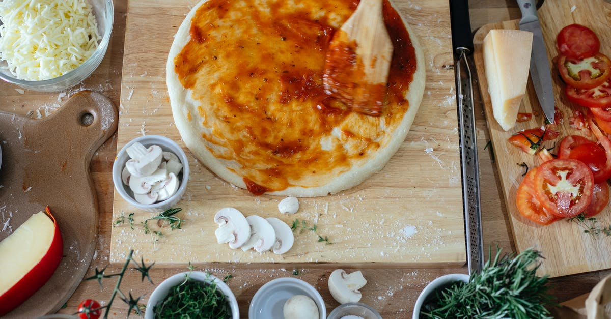 What alternatives are there to tomato based pizza sauces? - Top view of fresh vegetables and cheese on wooden cutting boards on table during process of preparing pizza in kitchen What alternatives are there to tomato based pizza sauces? - Top view of fresh vegetables and cheese on wooden cutting boards on table during process of preparing pizza in kitchen