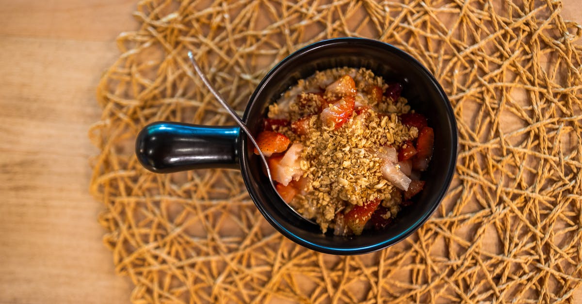 What are berry grains? - Top view of black ceramic plate of delicious mix of granola and strawberry placed on wooden table on morning breakfast What are berry grains? - Top view of black ceramic plate of delicious mix of granola and strawberry placed on wooden table on morning breakfast