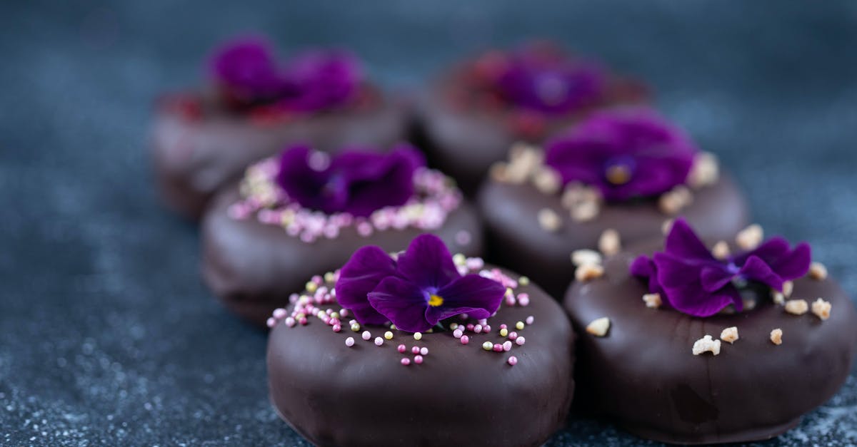 What are food combinations that trick your taste buds into tasting sweet? - Set of sweet doughnuts with chocolate glaze decorated with Viola flower What are food combinations that trick your taste buds into tasting sweet? - Set of sweet doughnuts with chocolate glaze decorated with Viola flower