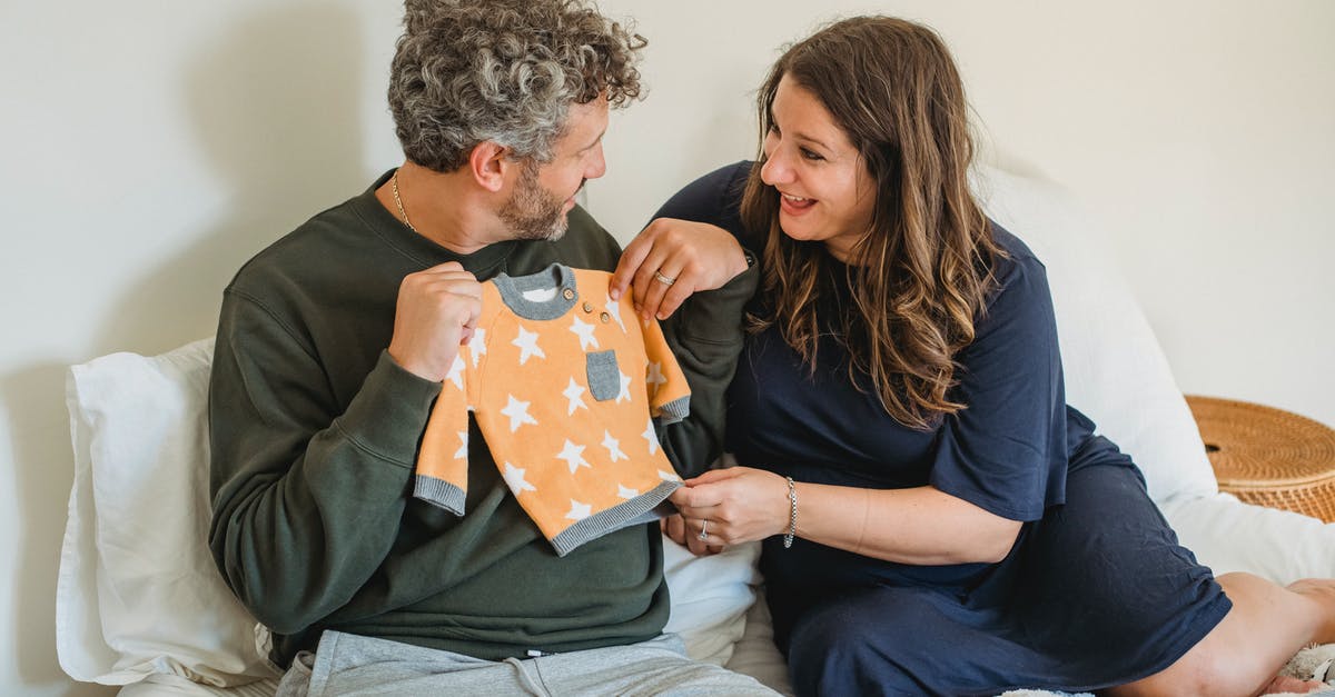 What are some things to consider when choosing a salt? - Cheerful pregnant couple resting on bed while preparing clothes for infant and looking at each other What are some things to consider when choosing a salt? - Cheerful pregnant couple resting on bed while preparing clothes for infant and looking at each other