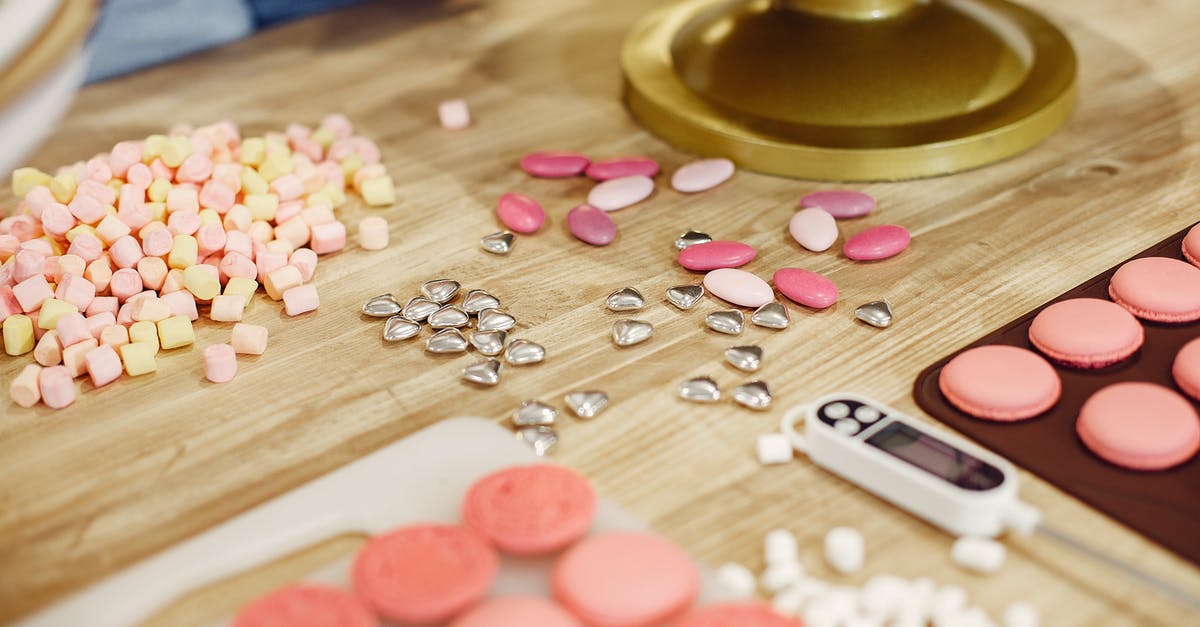 What are the differences between candy thermometers and meat thermometers? - Table with various shiny sprinkles placed near mat of macaroons and cooking thermometer in process of making delicious desserts in restaurant