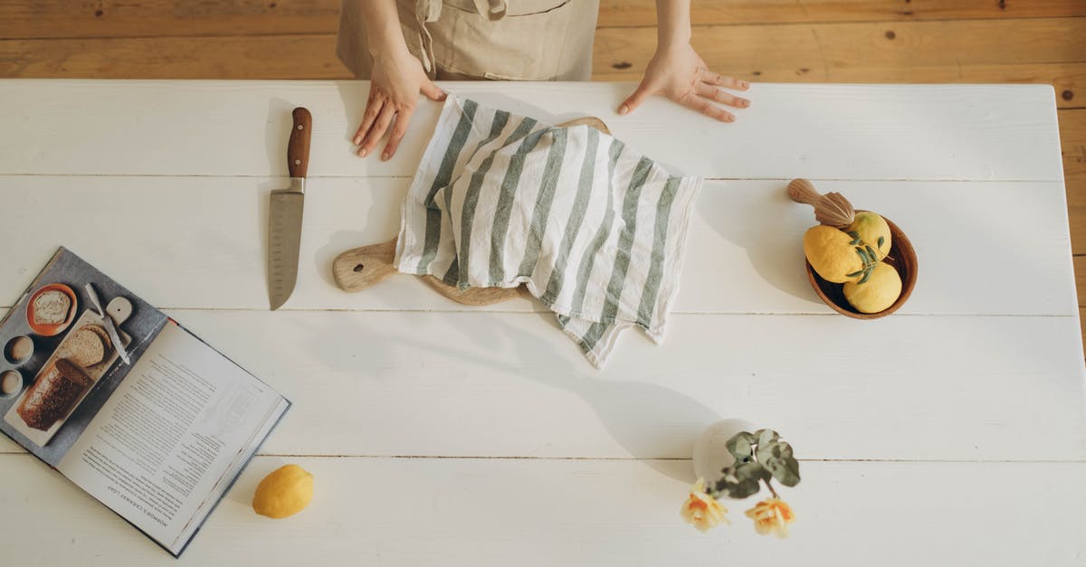 What are the key differences between lemons and meyer lemons? - Person in Gray Long Sleeve Shirt Holding White and Gray Stripe Textile