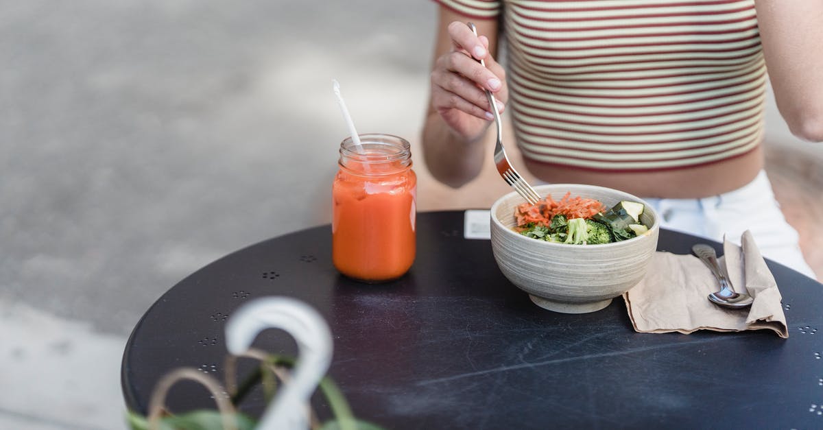 What are the transparent strands in this salad? - Crop woman with vegetable salad and smoothie in street cafeteria What are the transparent strands in this salad? - Crop woman with vegetable salad and smoothie in street cafeteria