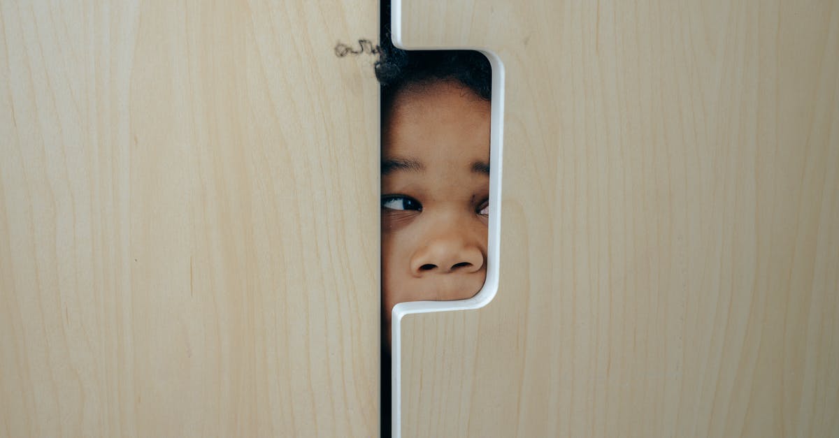 What are those little holes in some meat? - Anonymous funny little ethnic child hiding in wardrobe and peeping through hole while playing at home What are those little holes in some meat? - Anonymous funny little ethnic child hiding in wardrobe and peeping through hole while playing at home