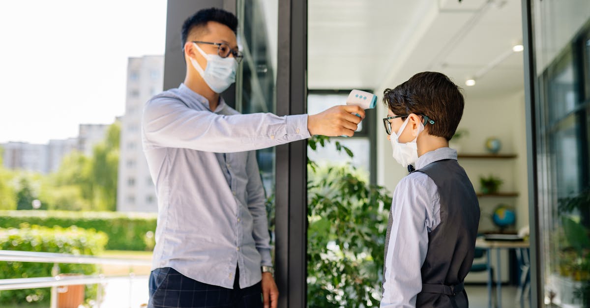 What can you do with an infrared thermometer? - A Man Checking a Boy's Temperature by a Doorway What can you do with an infrared thermometer? - A Man Checking a Boy's Temperature by a Doorway