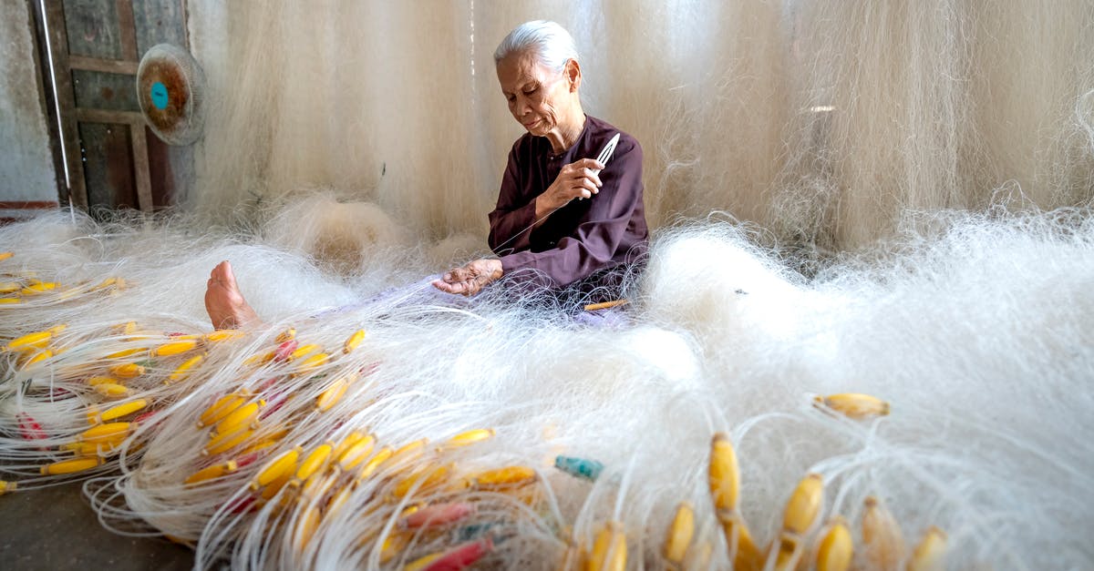 What causes butter to make risotto shiny? - Senior Asian woman making fishing net at home What causes butter to make risotto shiny? - Senior Asian woman making fishing net at home