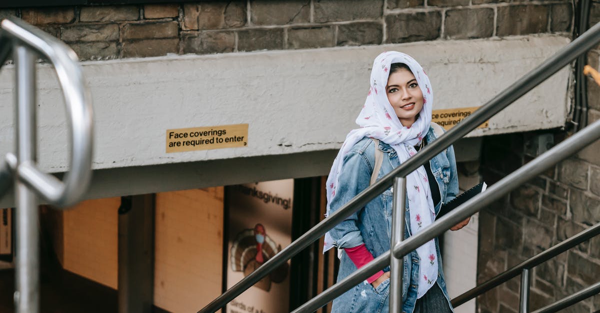 What causes popovers to rise so much? - Charismatic woman in casual wear and headscarf with notebook in hand rising on stairs from underpass and looking at camera while having walk in city What causes popovers to rise so much? - Charismatic woman in casual wear and headscarf with notebook in hand rising on stairs from underpass and looking at camera while having walk in city